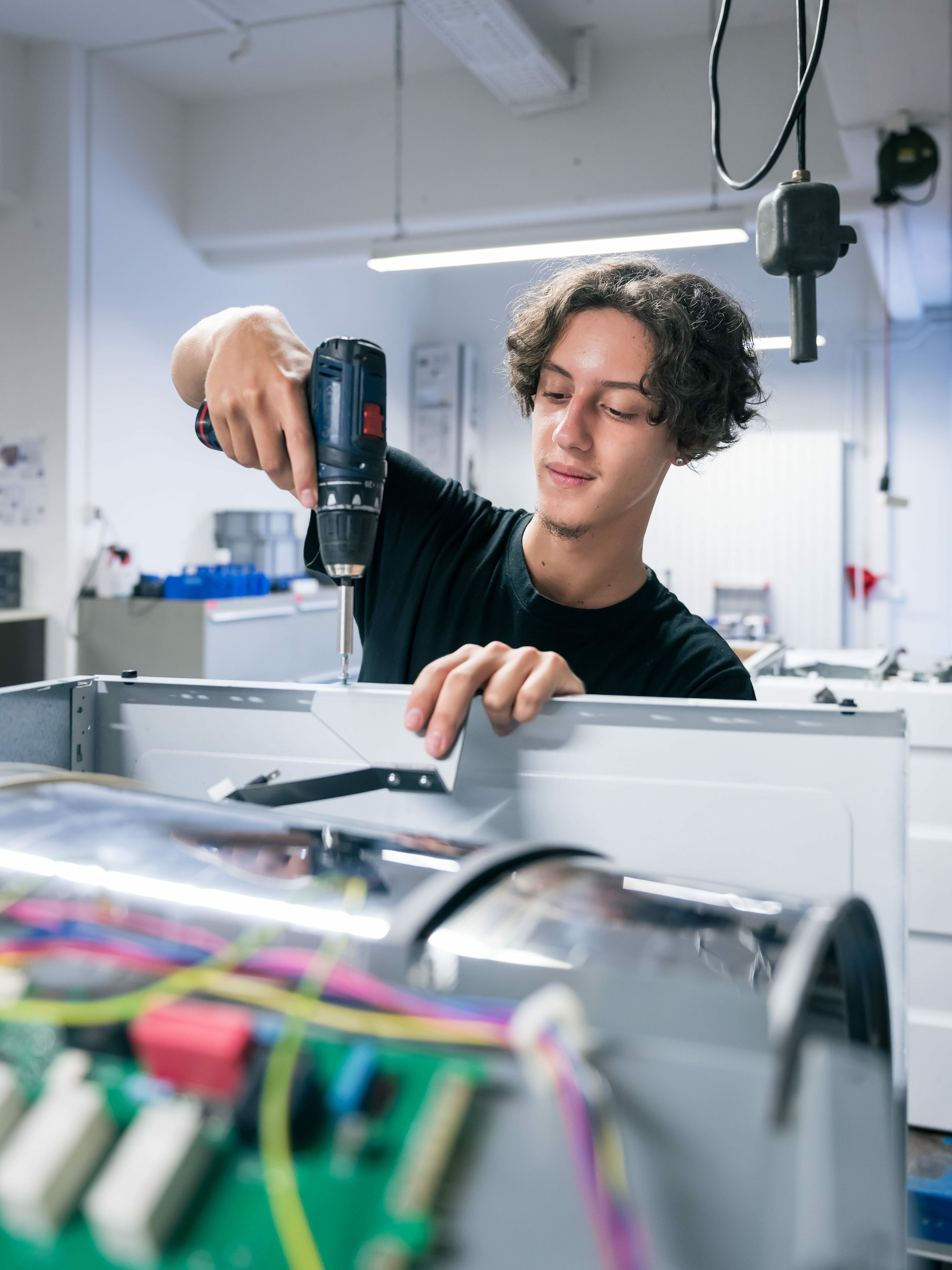 Bild Lehrling am offenen Gerät Schrauben