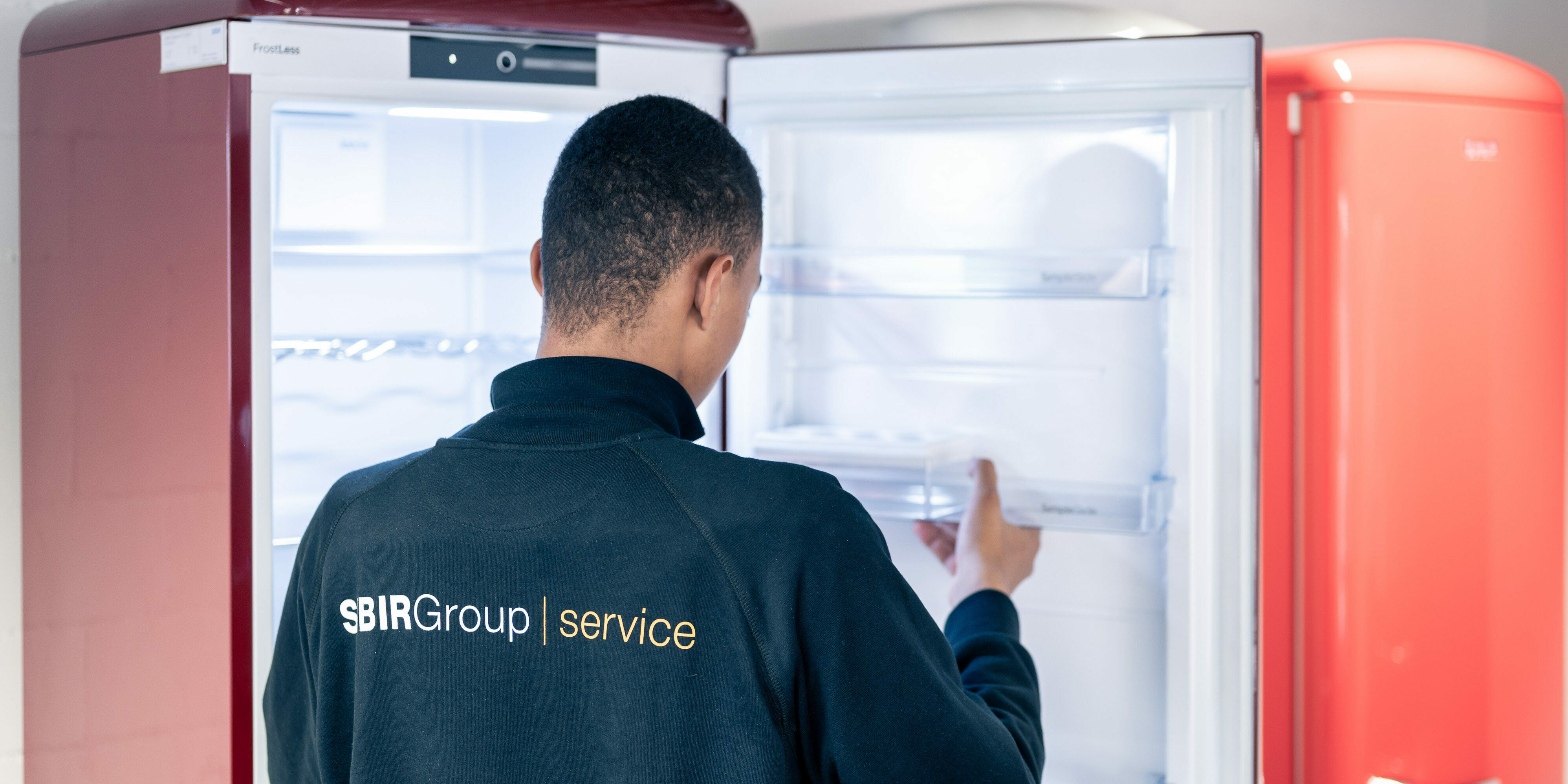 Technician works on a compartment on the refrigerator door